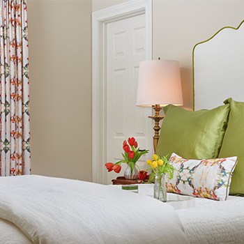 Bedroom with green pillows and lamp image